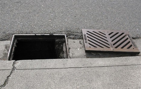 This photo illustrates the gaping hole left when a storm drain grate is stolen. Grates