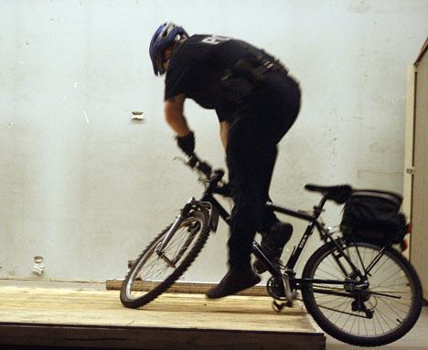 Officer Josh Haglan takes a tumble Tuesday while learning how to maneuver his bicycle over objects. The weeklong training took place in the old Lowe's building off Enchanted Parkway South. The course presented to the officers was taken from the International Police Mountain Bike Association.
