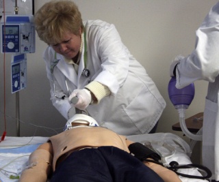 Oksana Buchholz inserts a chest tube to help SimMan breathe during an exercise at Highline Community College.