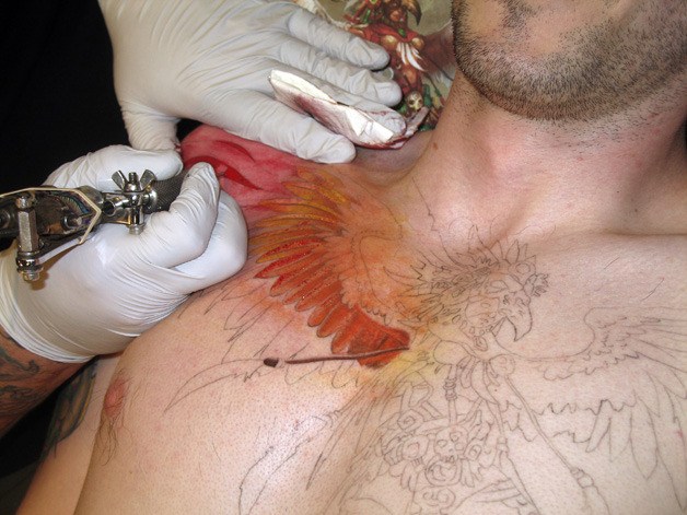 Peter Dominguez began to fill in the wings of a massive harpy across Derrick Burke's chest at All Hope Aside Tattoo in Federal Way.