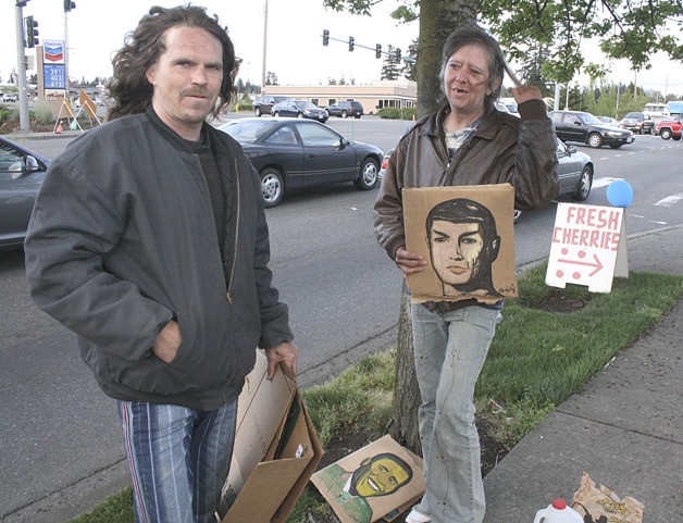 A homeless couple tries to earn a few dollars at a Federal Way intersection in this 2008 photo. Reach Out Federal Way operates winter shelters to serve the local homeless population with a meal and a place to sleep.