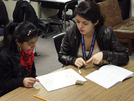 Federal Way High School student Vanessa Delatorre (right) works with Jasmine Guitterez on a math problem last Thursday at Illahee Middle School. Vanessa is a sign language student at Federal Way High School.