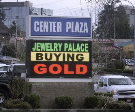 An electronic sign advertising a secondhand dealer that pays cash for gold and other precious metals can be seen roadside on South 320th Street.