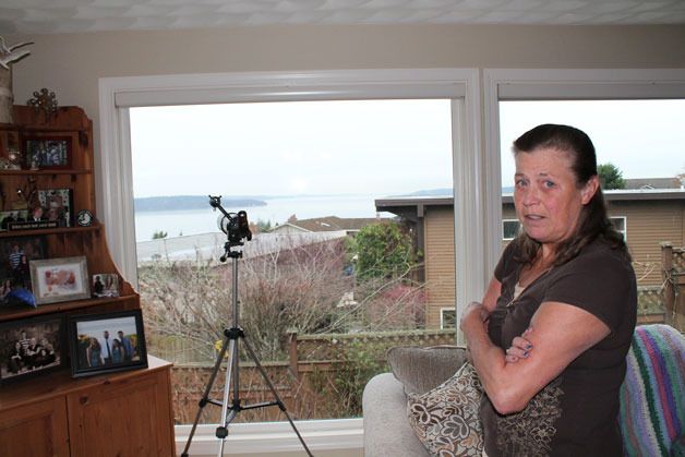 Barbara Pintler stands in front of her living room window where she's seen a drone hover multiple times since March.
