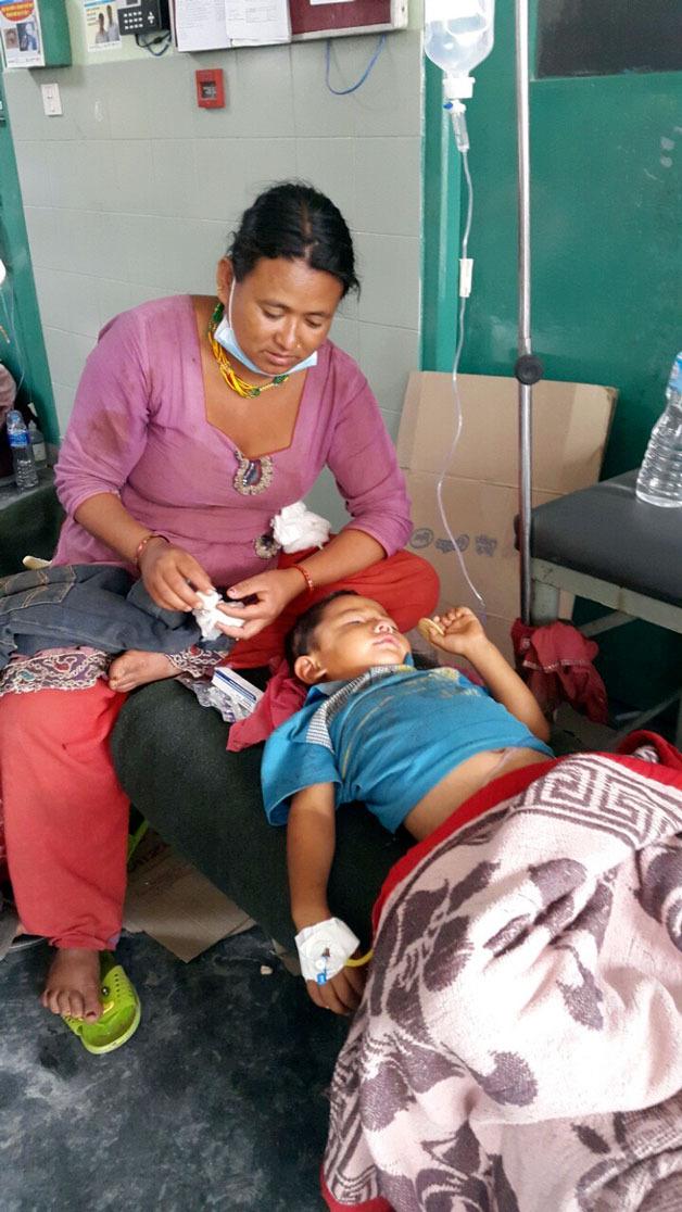 A boy injured during the 7.8-magnitude earthquake in Nepal receives medical help.