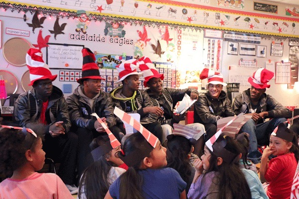 The Federal Way High School boys basketball team reads 'The Cat in the Hat Comes Back' to a kindergarten class at Adelaide Elementary.