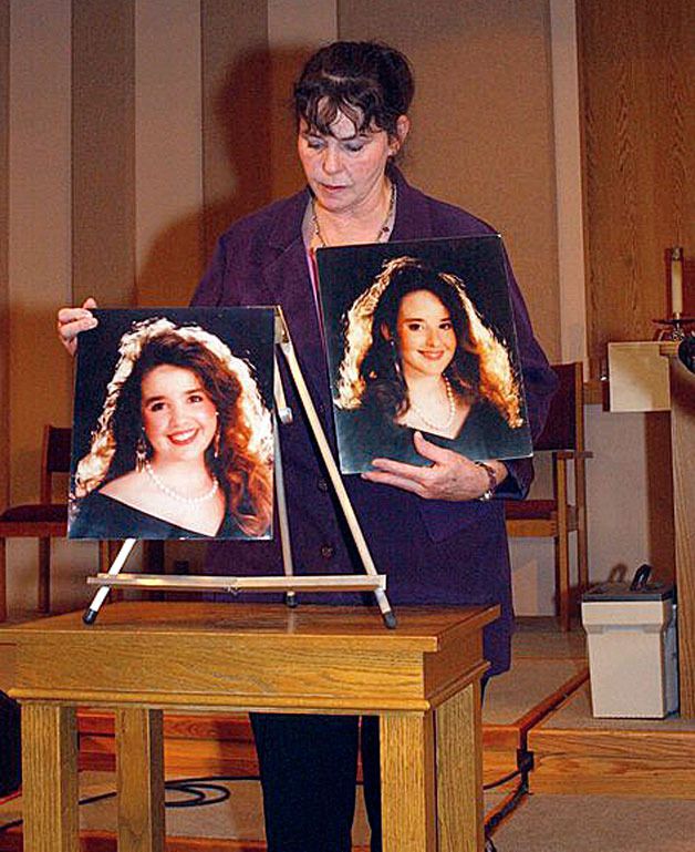 Priscilla Warmbo holds photographs of her daughters Sarah and Charity Warmbo. Her daughters were murdered as a result of domestic violence.