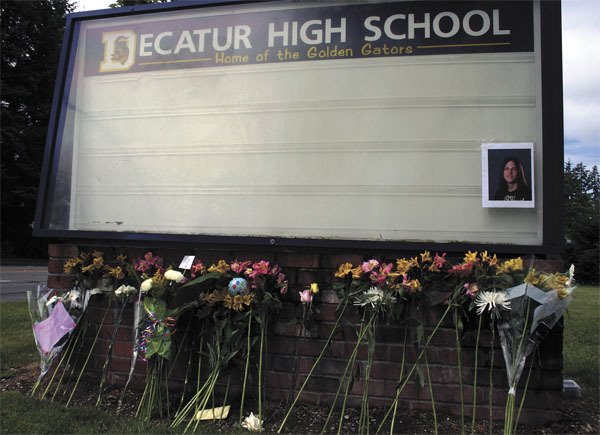 Flowers and messages were placed at Decatur High School’s billboard along South 320th Street for three students involved in a fatal crash. Two of the students died.