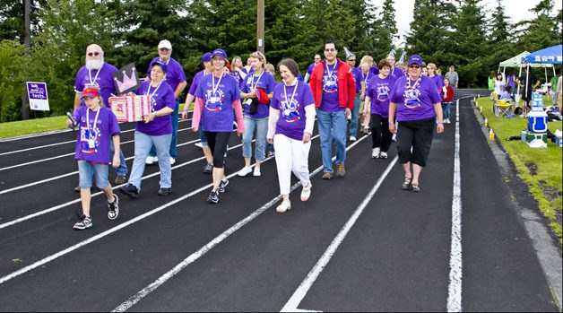 Walkers in purple shirts begin Federal Way’s 2010 Relay For Life with the Survivor Lap. Purple shirts symbolize a person who has survived cancer. The 2011 event takes place June 24-25 at Saghalie Middle School in Federal Way.