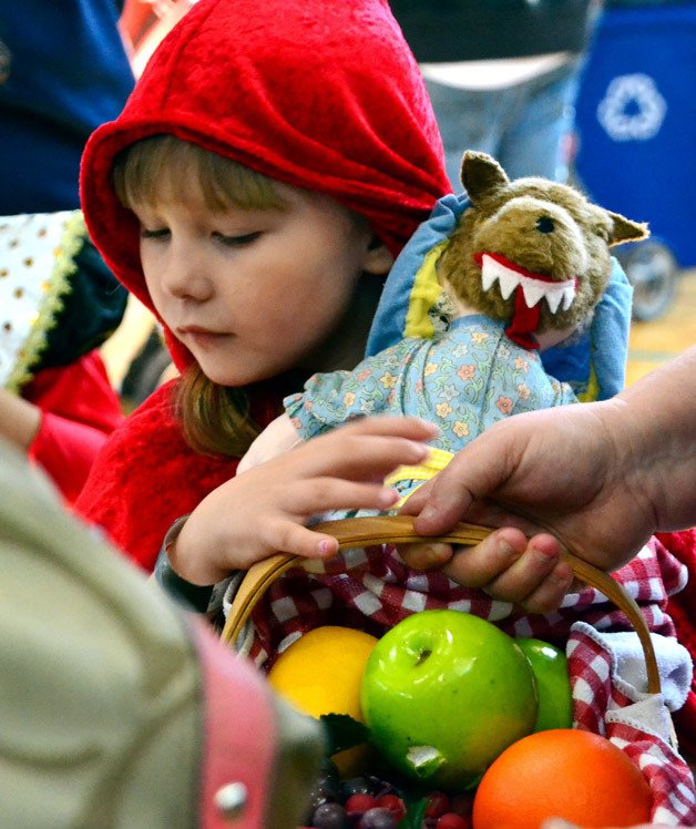 A girl dressed as 'Little Red Riding Hood' carries her stuffed wolf and basket of goodies during the city's annual Trick and Treats event at the Federal Way Community Center on Saturday.