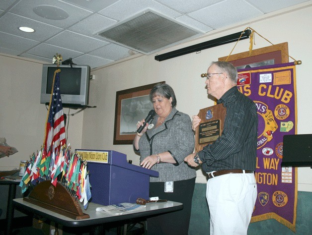 Lions Club District Governor Marilynn Danby presents Federal Way's incoming club president C.T. Purdom with a Melvin Jones Fellowship in recognition of raising $1