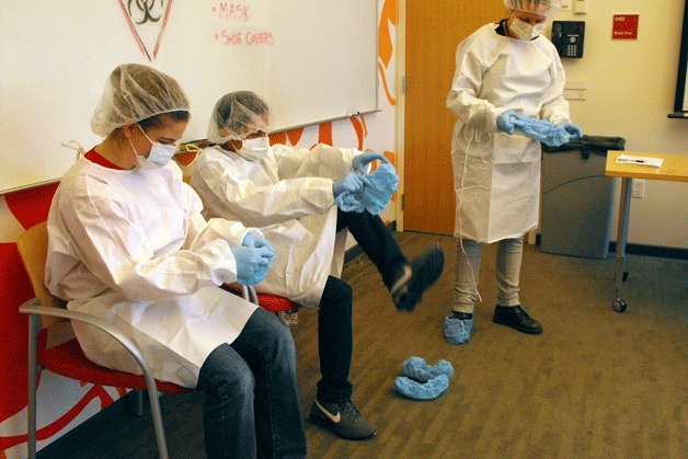 Students at Nautilus Middle School learn the importance of suiting up to avoid infection and transmission at the UW Medicine researcher facility.