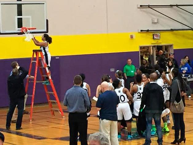 The Titans players and coaches took down the net after winning the district championship.