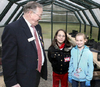 Lions Club member Bob Darrigan joins Lakeland Elementary School fourth-graders Jasmine McMillan and Kylee Mulligan-Veenker in a greenhouse at the Federal Way Senior Center.