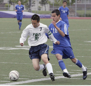 (Top) Beamer High School senior Daniel Nam (7) dribbles the ball against Bothell midfielder Yordan Rivera during the Titans’ 3-0 win over the Cougars Tuesday in the opening round of the Class 4A State Soccer Tournament in Sumner. (Below) Beamer freshman Ugo Okoli finished the game with an assist on a goal by Nam.