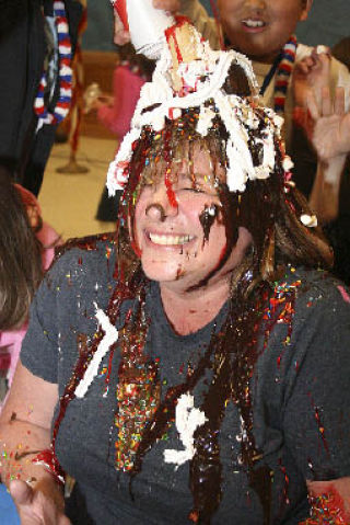 Nautilus Elementary principal Cindy Black laughs while a student tops her with whipped cream during an assembly Monday.