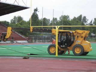 (Top) Workers tear up the old turf on the football/soccer field at Federal Way Memorial Stadium recently. The turf had been on the field for the past 13 years and will be replaced with grass-like Field-Turf. (Below) The new $50