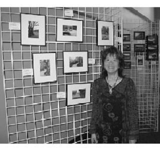 Mizu Sigumura stands next to Federal Way photo contest entries inside the Federal Way Community Center.