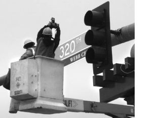 The first of 17 place markers identifying historical Federal Way roads was hung at the intersection of Pacific Highway South and South 320th Street Tuesday morning. The highway used to be known as Seattle-Tacoma Road and the intersection of that and South 320th Street was known as Webb Corner.