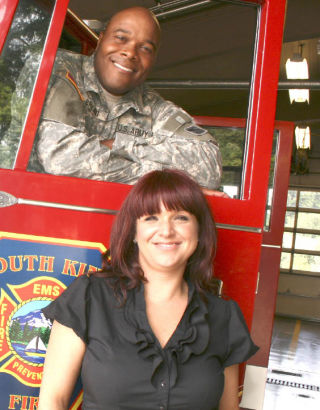 First Lt. Robert Bryant of the Army National Guard’s 81st regiment smiles from the driver’s seat of a South King Fire Department fire truck with his wife