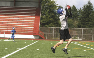 A Federal Way High School football player grabs a pass during the team’s second day of practice Thursday morning on new Field Turf at Federal Way Memorial Stadium. The Eagles’ first game will be at home at Memorial Stadium Sept. 4 against Auburn High School.