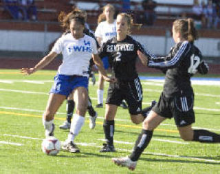 Federal Way High School’s Joanne Packer takes a shot against Kentwood defenders Emily Alonzo (12) and Andrea Jensen (2) Tuesday. Kentwood won the game