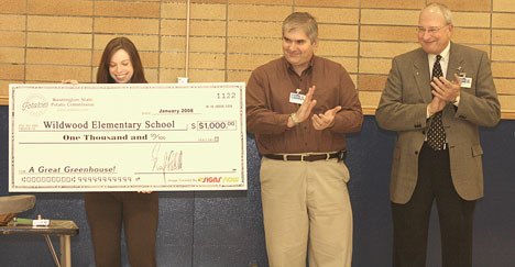 Federal Way School Board President Dave Larson and Superintendent Tom Murphy applaud as a representative from the Washington State Potato Commission hands over a check for $1
