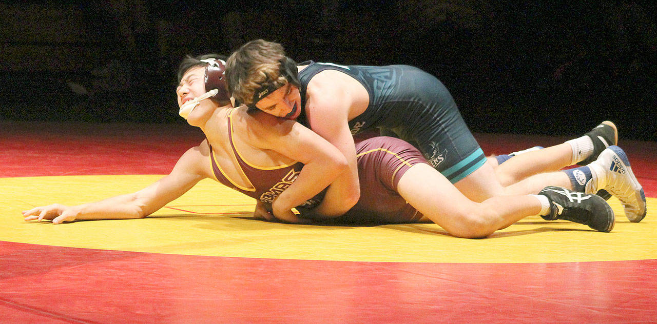 Auburn Riverside’s Mikah Fathers tries to put away his match against Thomas Jefferson’s Jared Tran, who winces from his efforts, during their match in the 126-pound weight class Wednesday. Thomas Jefferson fell to the Ravens. Jessica Keller, the Mirror