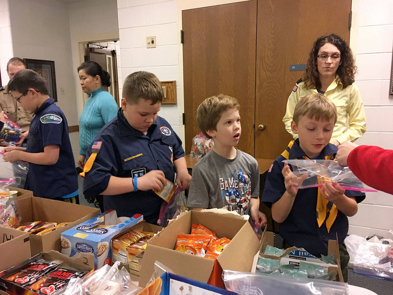 Members of the Church of Jesus Christ of Latter-day Saints Cub Scouts packs 305 and 301, led by committee chairs Dan Miller and Becky Kelly, on Dec. 12 assemble care kits for the homeless who visit the Federal Way Day Center. The care kits included hygiene items and snack food and fleece scarves the boys made. The day center relies on donations like these from the community. Contributed photo