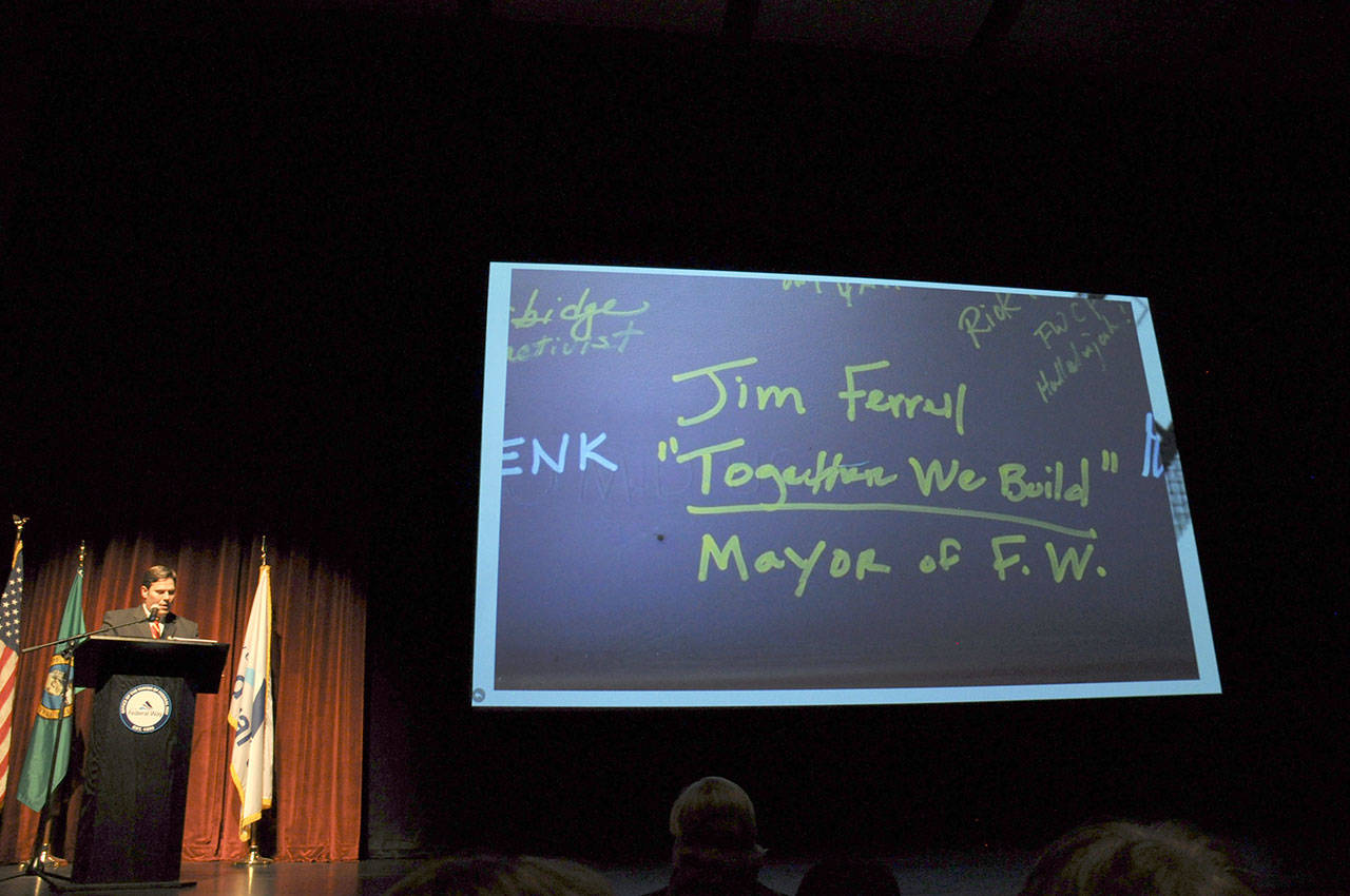 During his State of the City address on Monday, Mayor Jim Ferrell shows a picture of what he wrote on a beam placed in the Federal Way Performing Arts and Event Center during construction. Below his name, Ferrell wrote, “Together we build,” which was also the theme of the speech he gave in the PAEC. HEIDI SANDERS, the Mirror