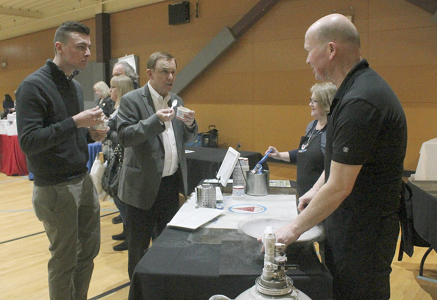 King County Councilman Pete von Reichbauer, center, and his legislative staff director Tyler Pichette, left, enjoy ice cream while talking to Sub Zero Ice Cream owner Jack Walsh and his wife, Judy, at the Best of Federal Way reception Wednesday at the Federal Way Community Center. Walsh and his wife mixed up ice cream using liquid nitrogen at one of the vendor booths at the event. Jessica Keller, the Mirror