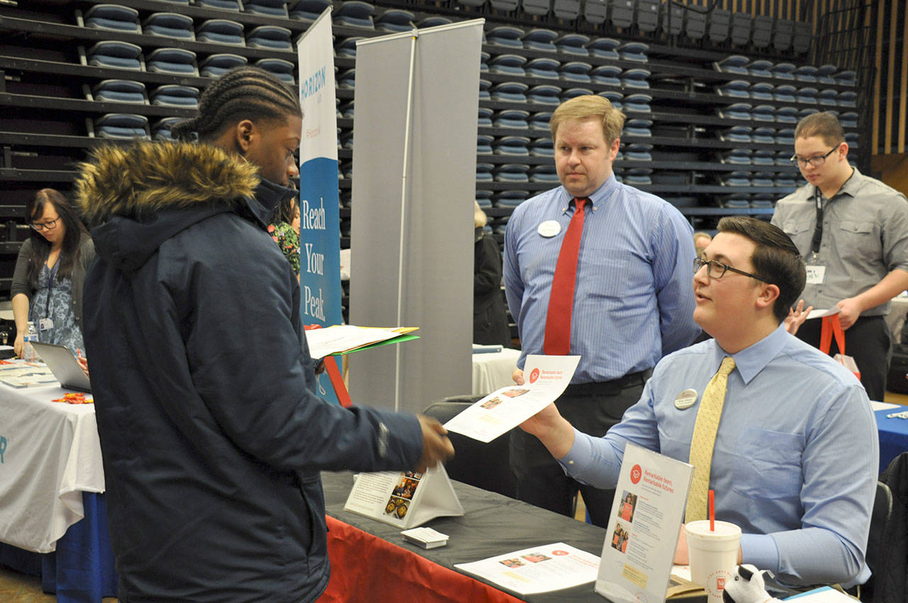 Shamaun Guiden, a sophomore a Decatur High School, left, gets employment information from DJ Pelphs, center, and Bruce Johnson, of Chick-Fil-A. HEIDI SANDERS, the Mirror