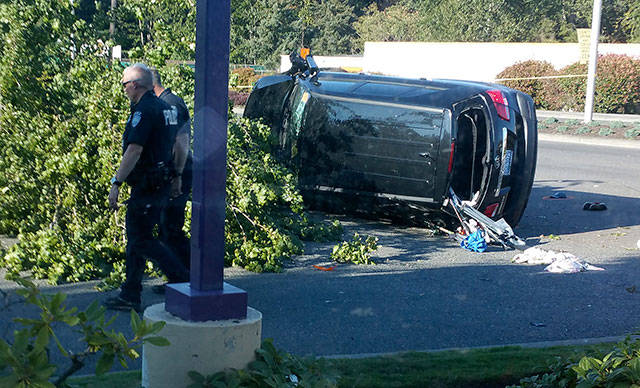 Kent Police investigate the scene of a July 25 crash that killed a pedestrian on Pacific Highway South. The driver of the vehicle who struck the pedestrian also hit a tree and another car before landing on its side. COURTESY PHOTO