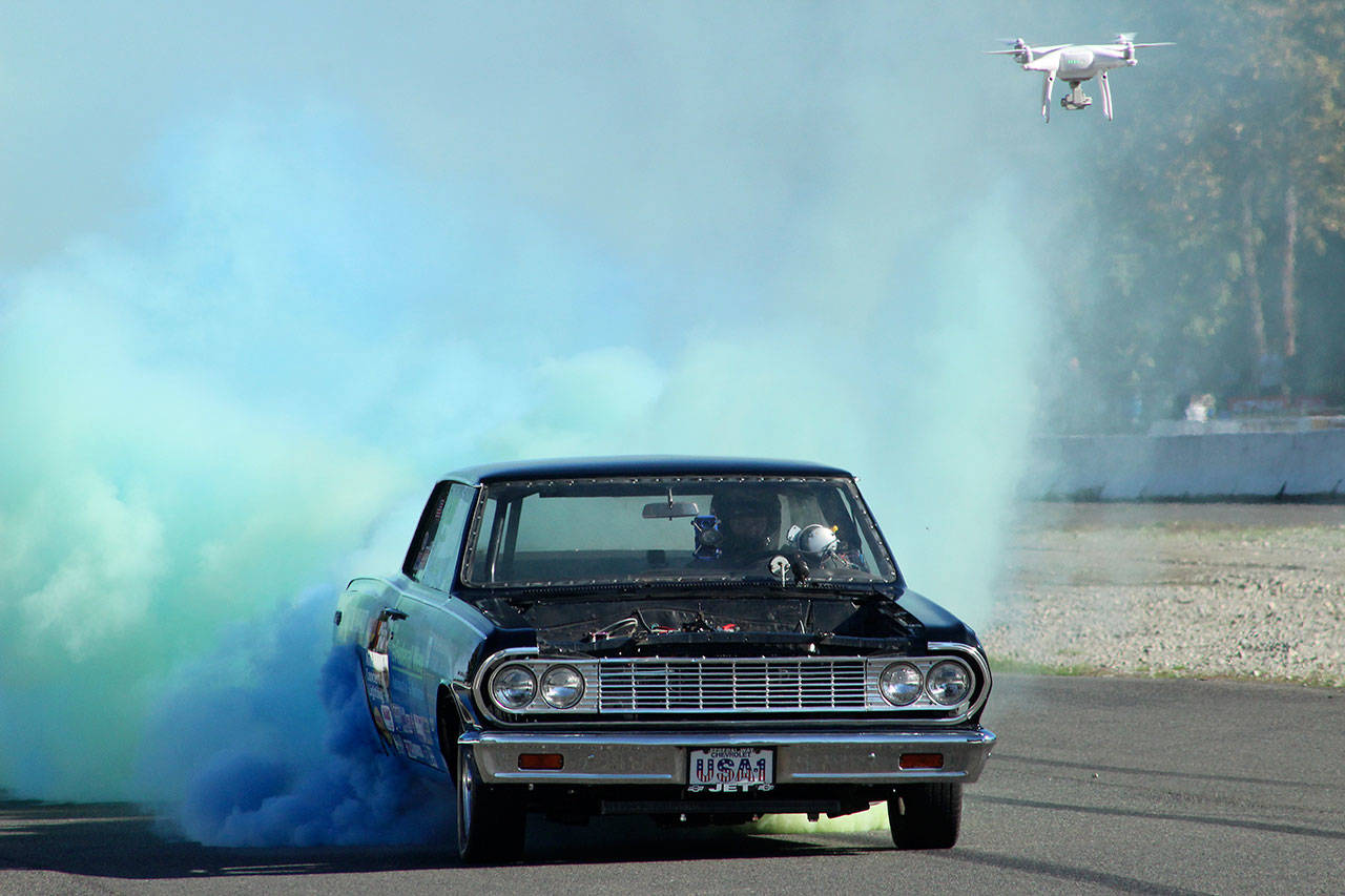 Ron Buckholz used specialized blue and green dye tires from Australia to show some Seahawks pride during his world record-setting burnout. Olivia Sullivan/staff photo