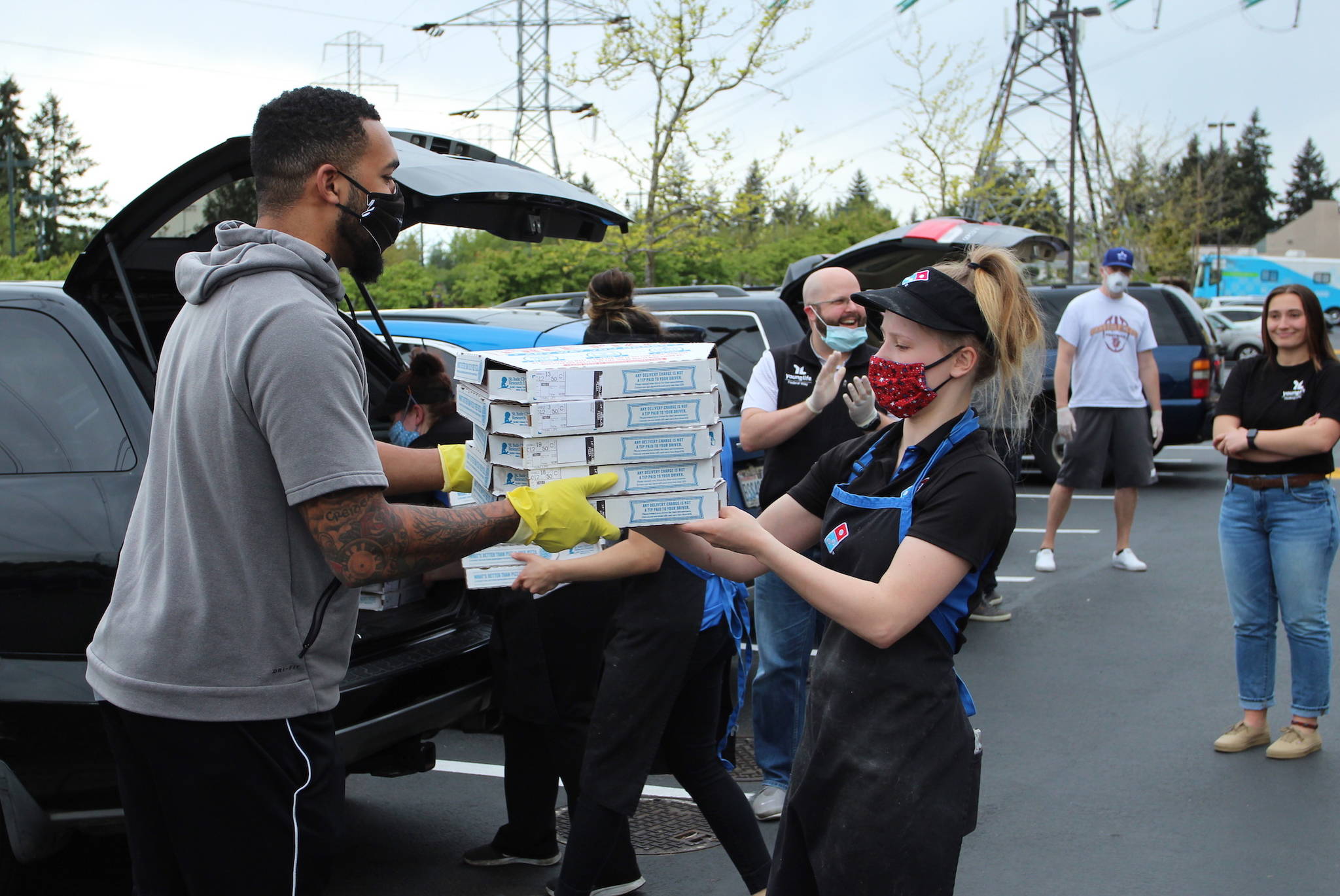 A Domino’s employee hands a stack of pizzas to Federal Way leader Keenan Curran on May 4. Olivia Sullivan/staff photo