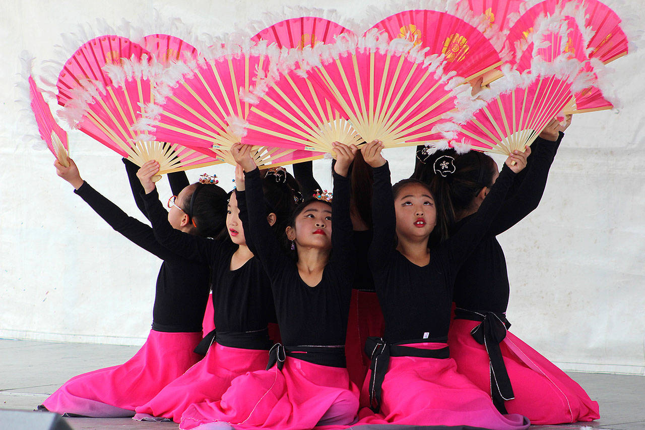 Kids of God Academy (KOGA) raise brightly colored fans during their performance at the Flavor of Federal Way multicultural festival in 2019. File photo