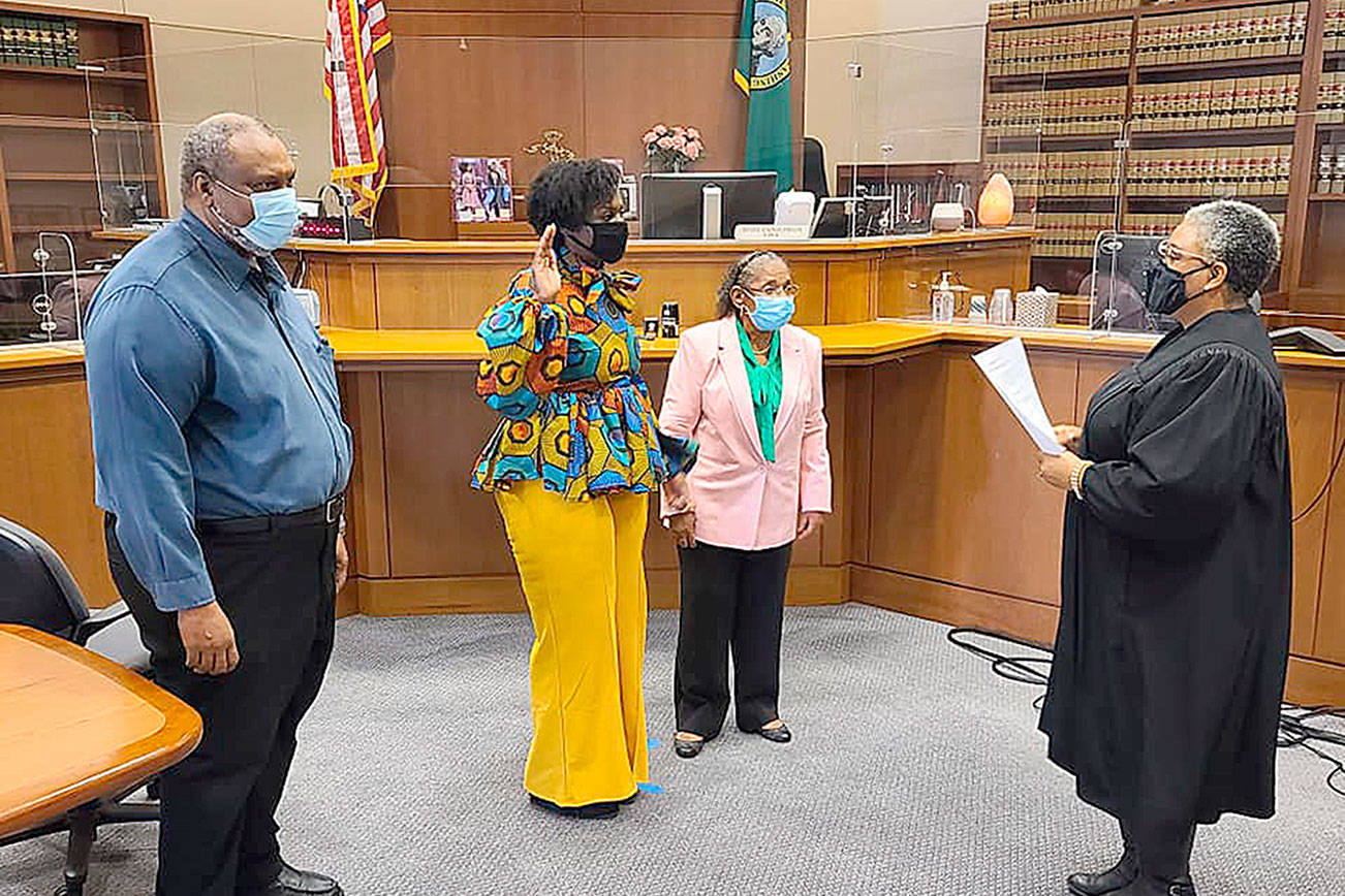 State Rep. Jamila Taylor is sworn in by Superior Court Judge Nicole Phelps with her parents, Dr. Quintard Taylor, left, and Carolyn F. Taylor on Jan. 10. Courtesy photo