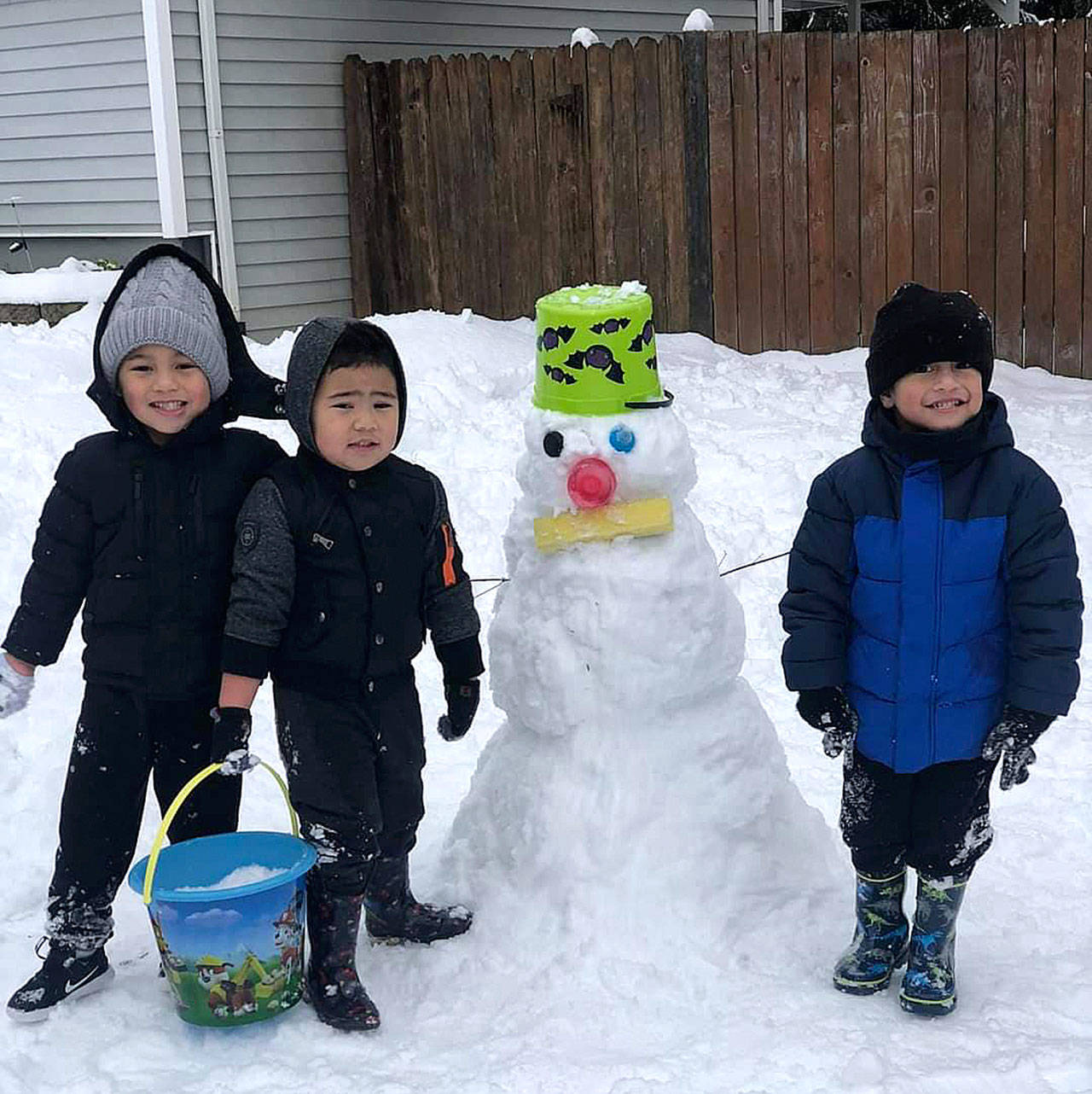 Darius, 5, Kayden, 3, and Toamalama, 3, enjoy the snow day with their snowman. Photo courtesy of Frances S. Papatu