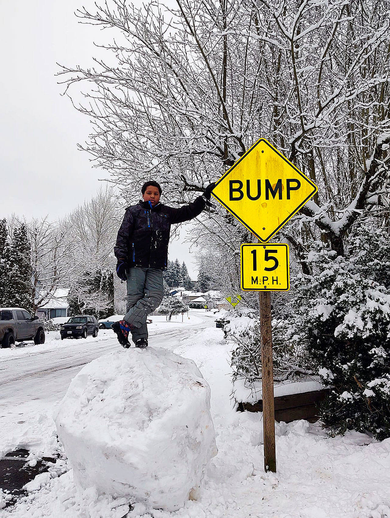 Nine-year-old Aarron Schild stands on top of a massive snowball in Federal Way during last weekend’s snowstorm. Photo courtesy of Kari Sandstrom Schild