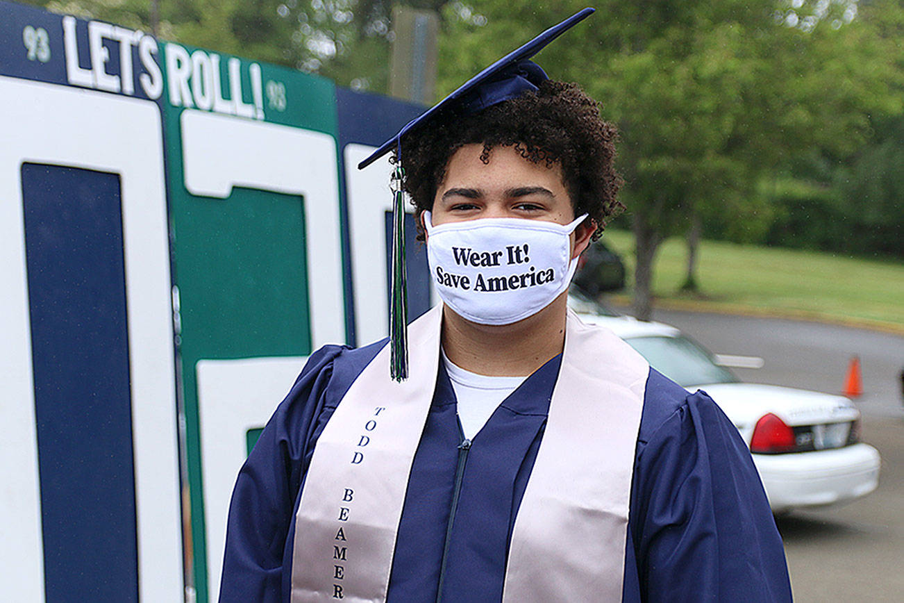 Senior Tayshon Cottrell dons his graduation cap and gown, along with a face mask reading: “Wear it! Save America” at Todd Beamer High School’s virtual graduation walk recording on May 20, 2020, in Federal Way. Olivia Sullivan/the Mirror