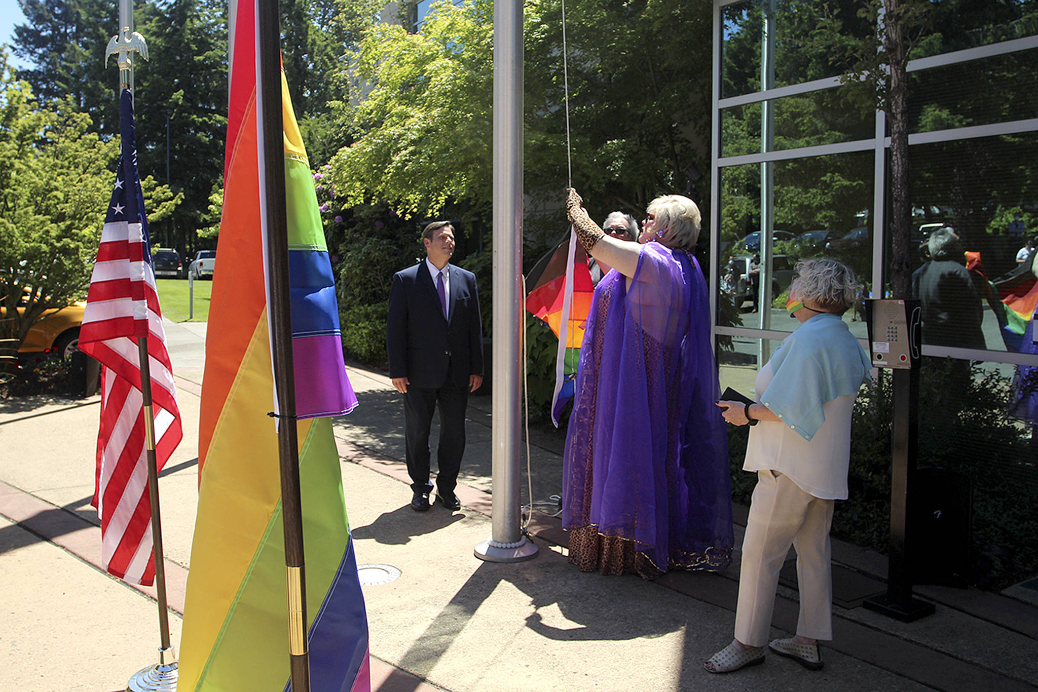 Resident Serena Starr, middle, helps raise the pride flag in Federal Way on June 1. Olivia Sullivan/the Mirror