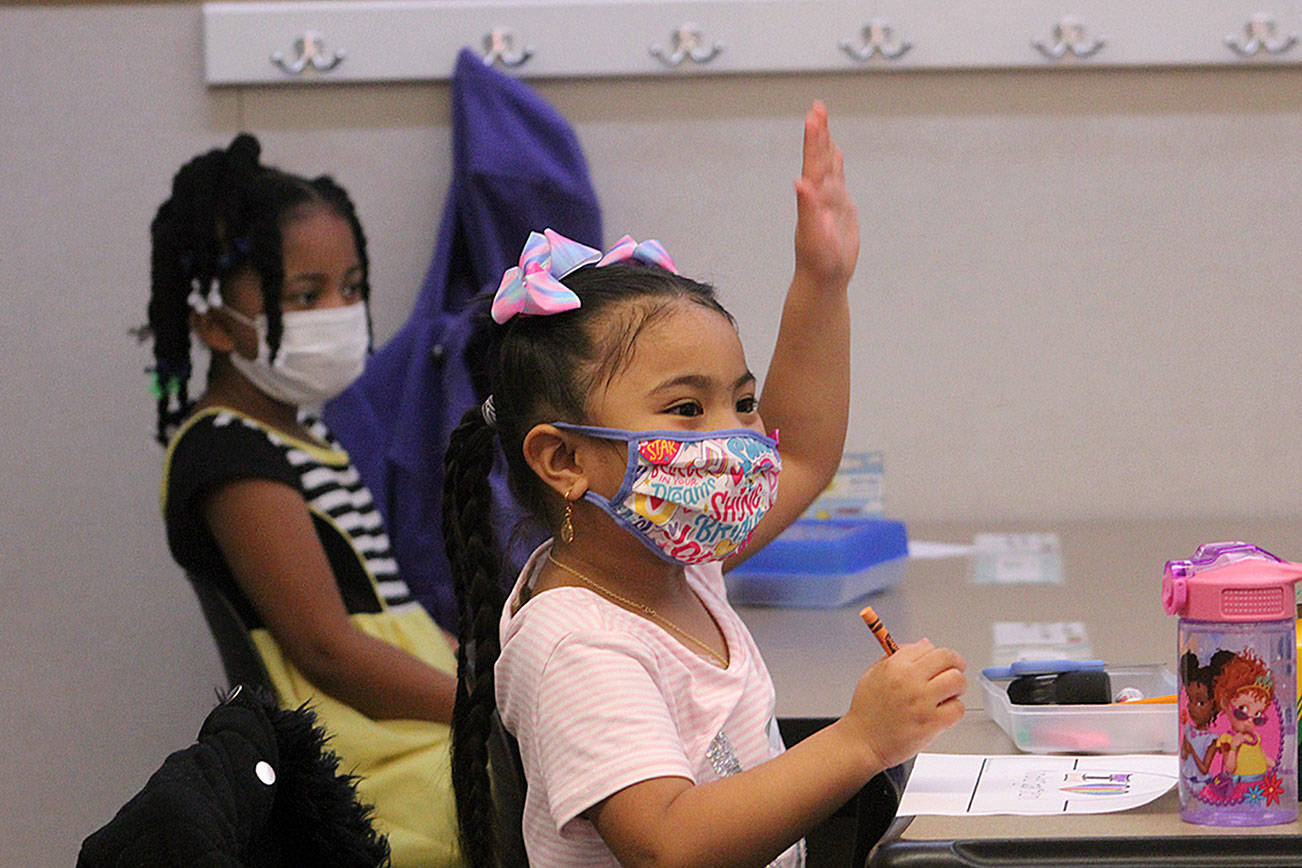 A kindergarten student at Panther Lake Elementary raises her hand during attendance on the first day of in-person learning on March 15. Olivia Sullivan/the Mirror