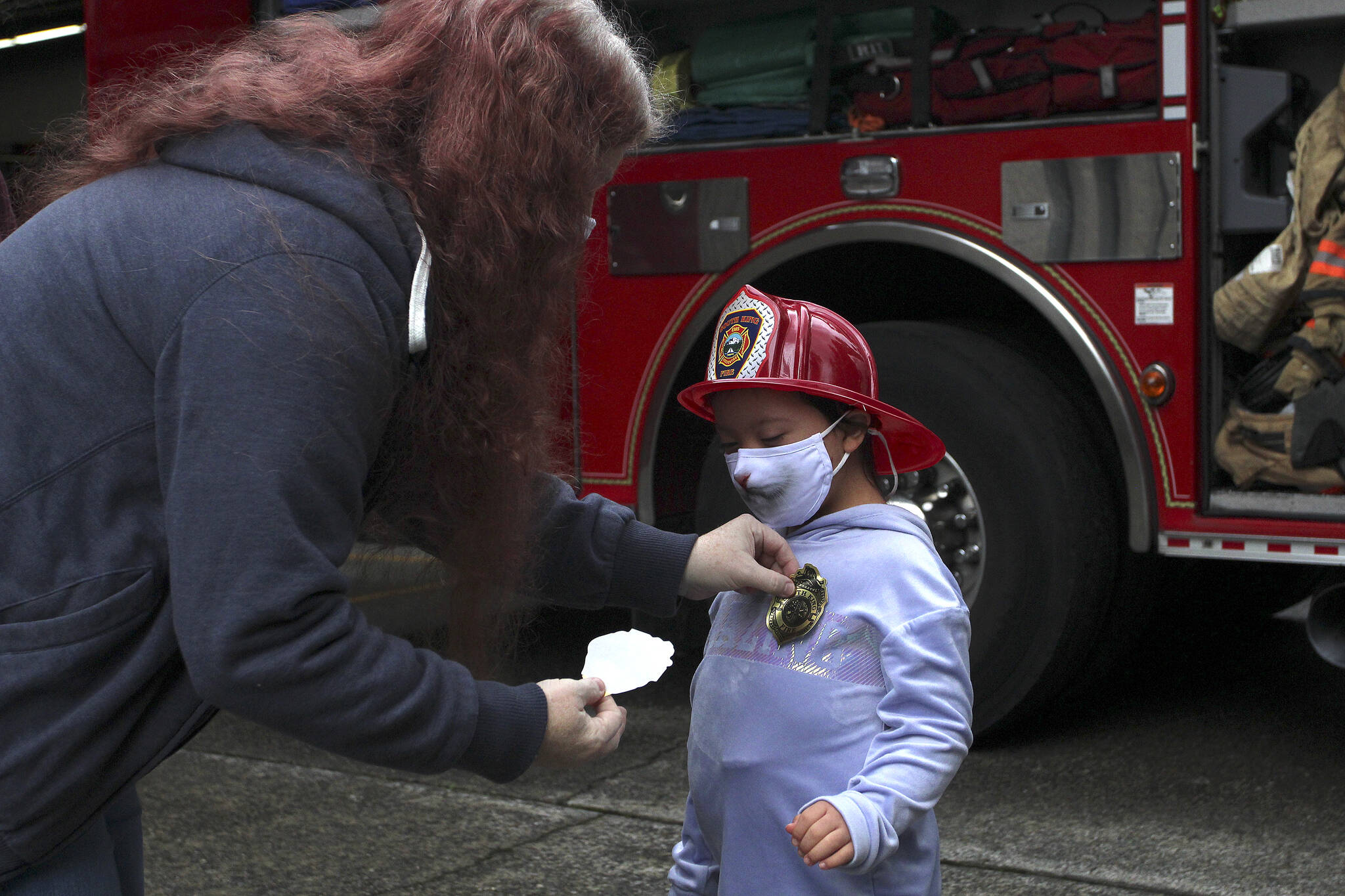 Arianna Graham dons a firefighter helmet and a new badge sticker at Station 62 on Oct. 14. Olivia Sullivan/the Mirror