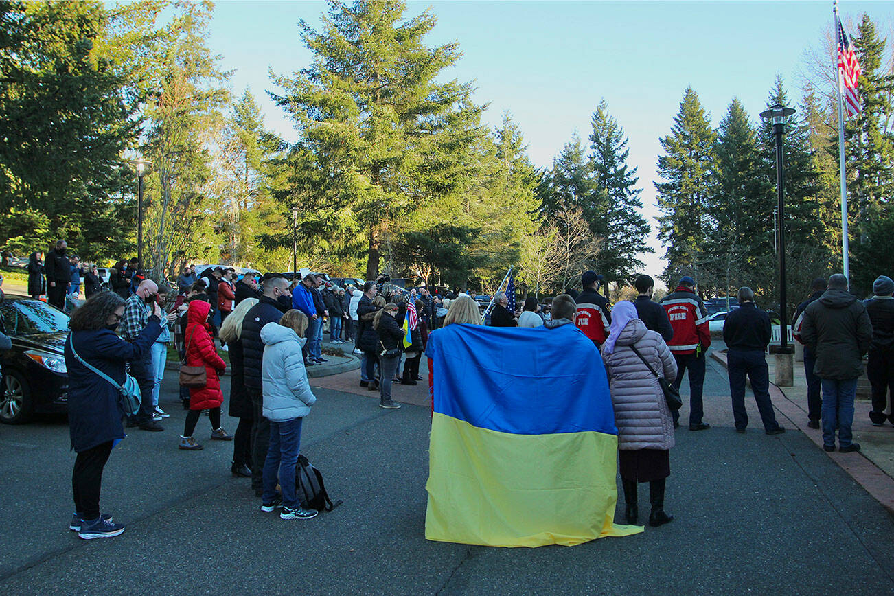 Crowd members drape the Ukrainian flag over the shoulders on Feb. 25 at Federal Way City Hall where community members and elected officials raised the Ukrainian flag. Olivia Sullivan/the Mirror
