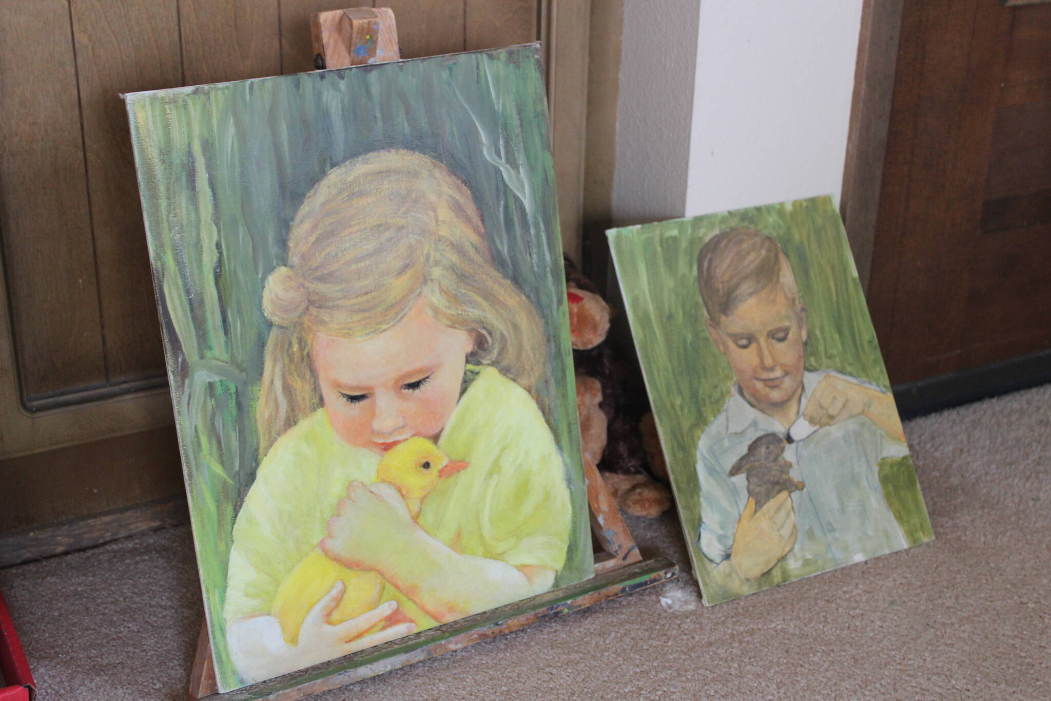 Along with sculpture, Irene Graham is a talented painter, whose late son Michael inspired the painting on the right, showing a young Michael feeding a small rabbit. Photo by Bailey Jo Josie/Sound Publishing