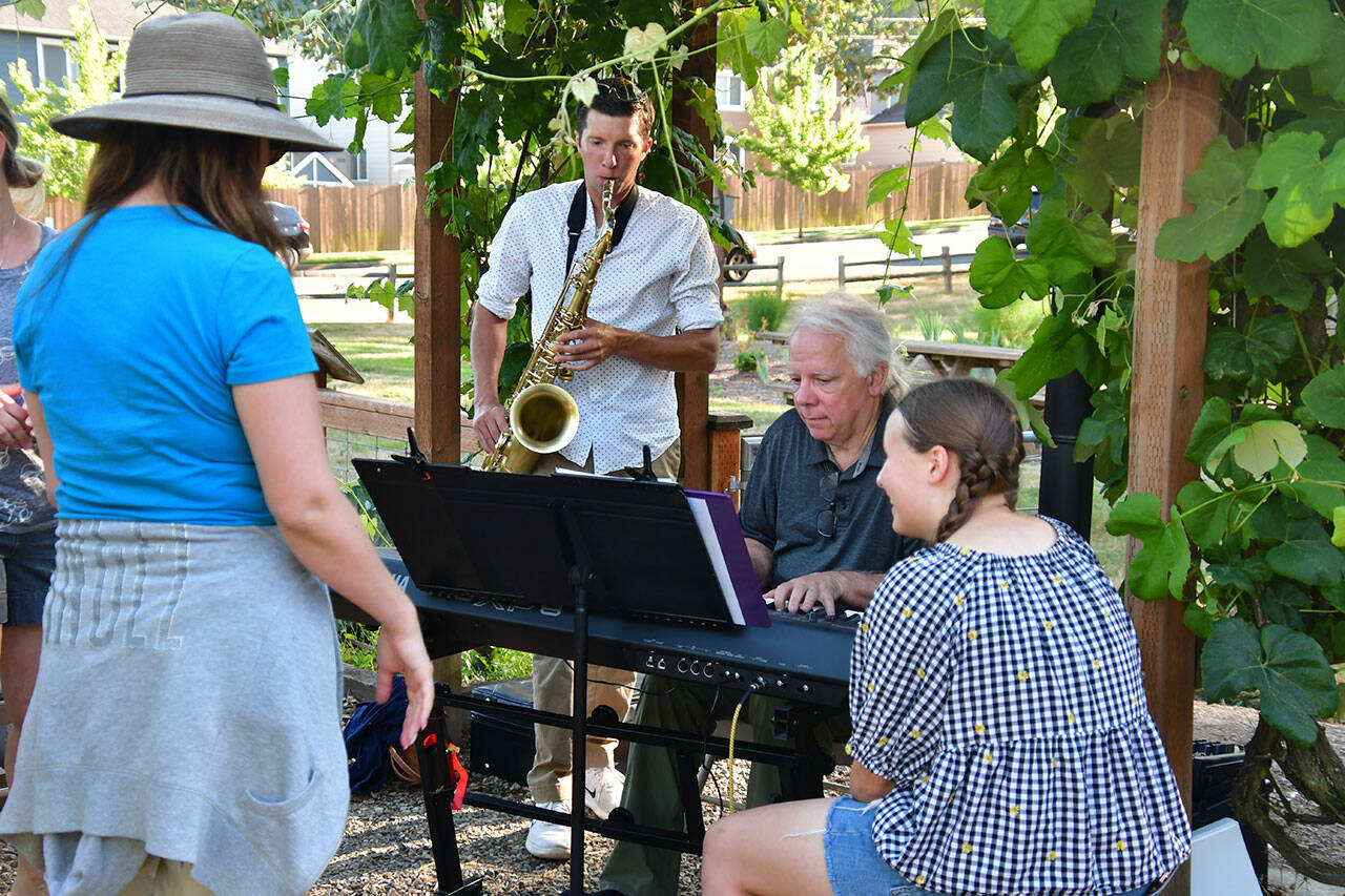 People play some tunes at the Light of Christ Community Garden on Aug. 2. Photo by Bruce Honda