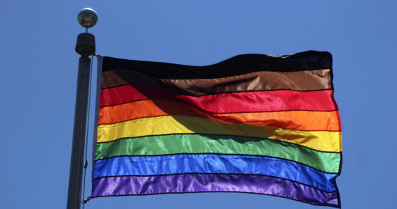 The diversity pride flag flies above Federal Way City Hall in 2021. In addition to the traditional six colors, the flag also includes a black stripe for diversity and a brown stripe for inclusivity. Olivia Sullivan/the Mirror