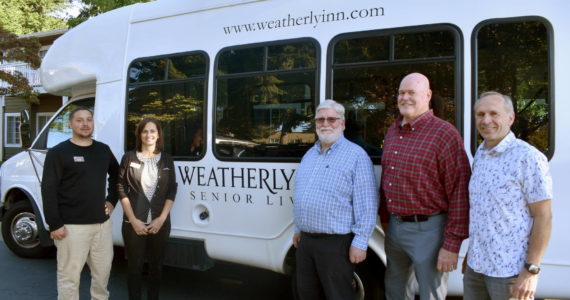 From left to right: Weatherly Inn Assisted Living Project Manager Joshua Magana and General Manager Andrea Peterson, and Christ’s Church leaders Mac Hoover, Jeff Moorehead and Jim Low each pose for a picture with the shuttle van Weatherly Inn has donated to the church. Photos by Alex Bruell.
