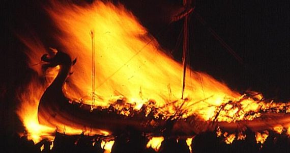 Image by Anne Burgess and used under a Creative Commons Attribution license
This image shows a galley being consumed by flames during a traditional Scottish “Up Helly Aa” fire festival in 1973. The ceremony marks the end of the Yule season. Once the longship has burned and the flames die down, guizers sing the traditional song “The Norseman’s Home” before going on to a night of partying.
This image shows a galley being consumed by flames during a traditional Scottish “Up Helly Aa” fire festival in 1973. The ceremony marks the end of the Yule season. Once the longship has burned and the flames die down, guizers sing the traditional song “The Norseman’s Home” before going on to a night of partying. Image by Anne Burgess and used under a Creative Commons Attribution license