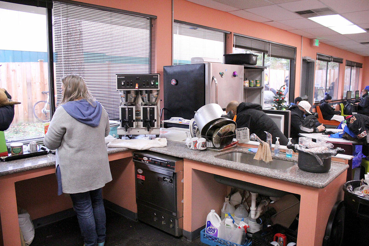 People experiencing homelessness use the kitchen facilities at the Federal Way Day Center, which offers showers, laundry, space for meal preparation, and other services for those in need. (Sound Publishing file photo)